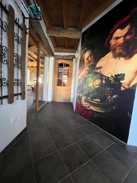 De hal met tegelvloer en het schilderij op de muur.