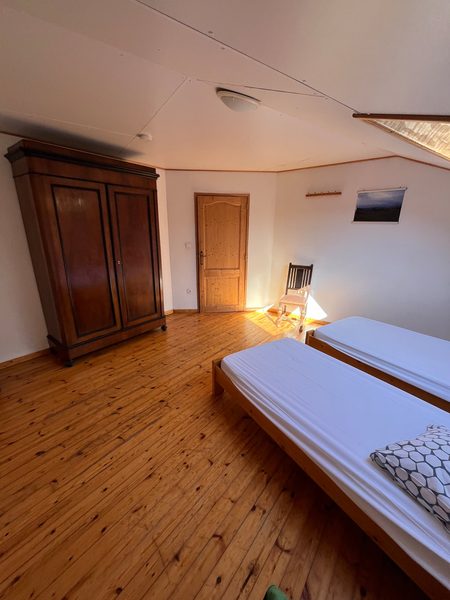 Slaapkamer met tweepersoonsbed en houten vloer.