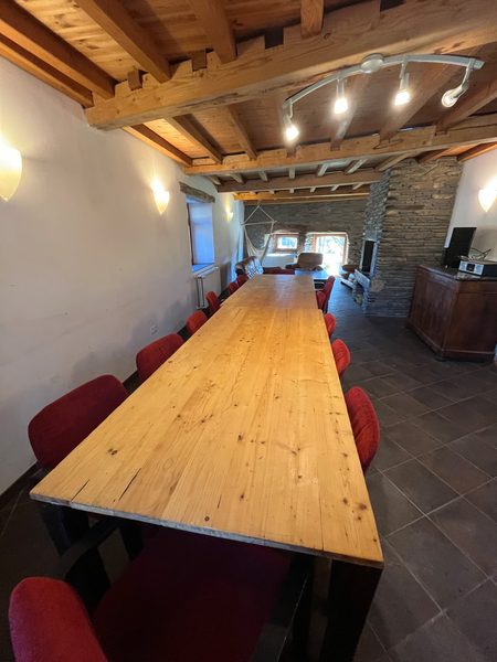 De lange eettafel in de woonkamer, onder het balkenplafond.