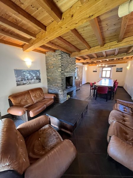 De woonkamer met leren fauteuils en de lange houten tafel.